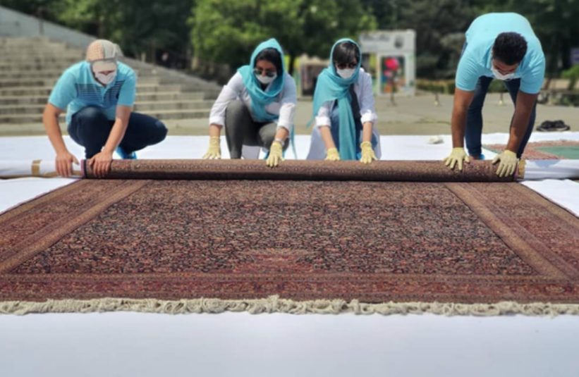 A restoration team rolling out a carpet