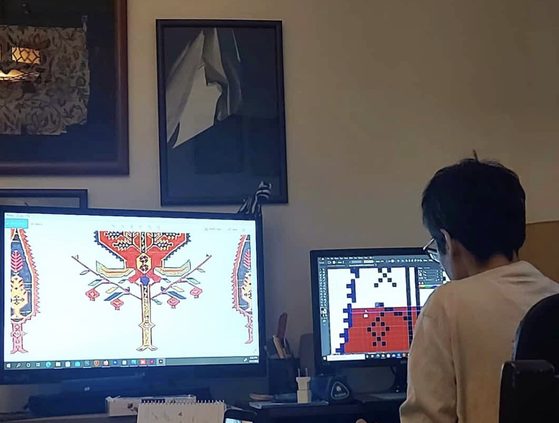 Working on a carpet design at the computer