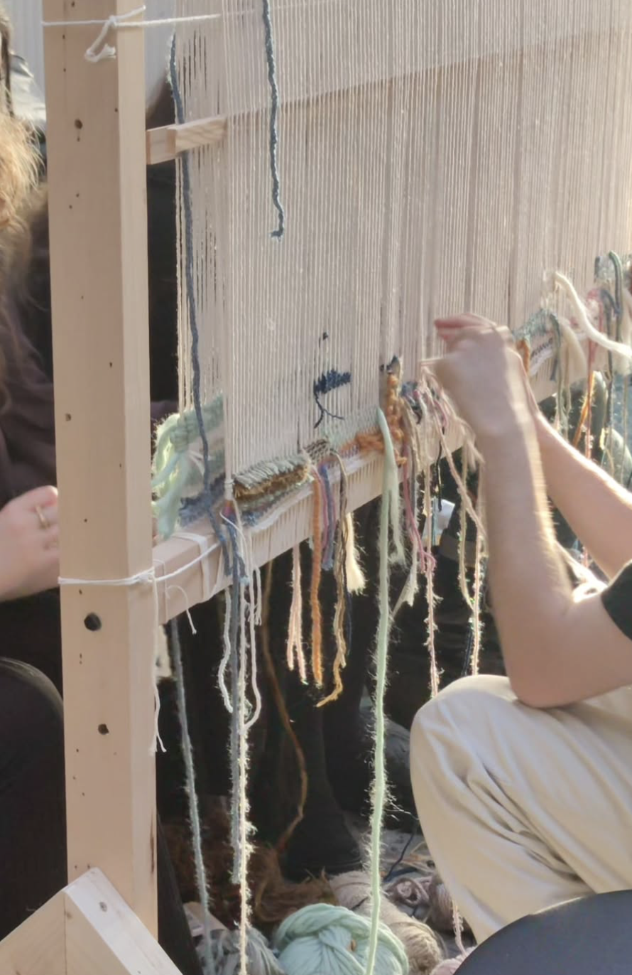 Participants weaving together at the workshop loom
