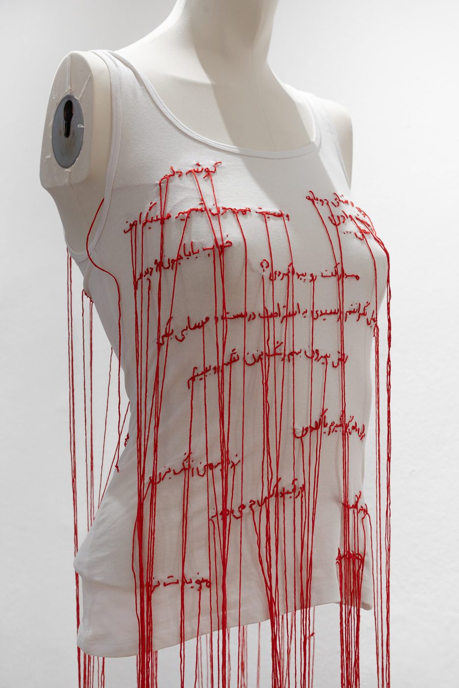 A white dress threaded with red yarn