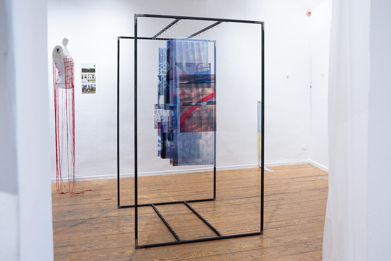A suspended frame with woven panels in the gallery