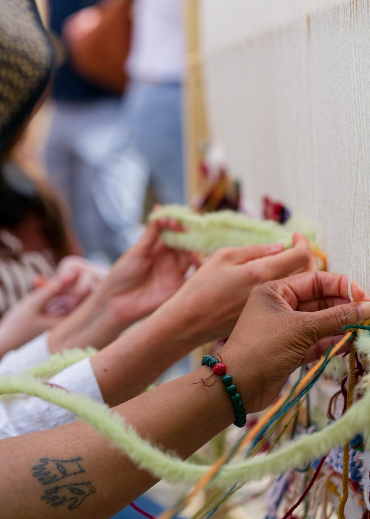 Hands knotting coloured yarn