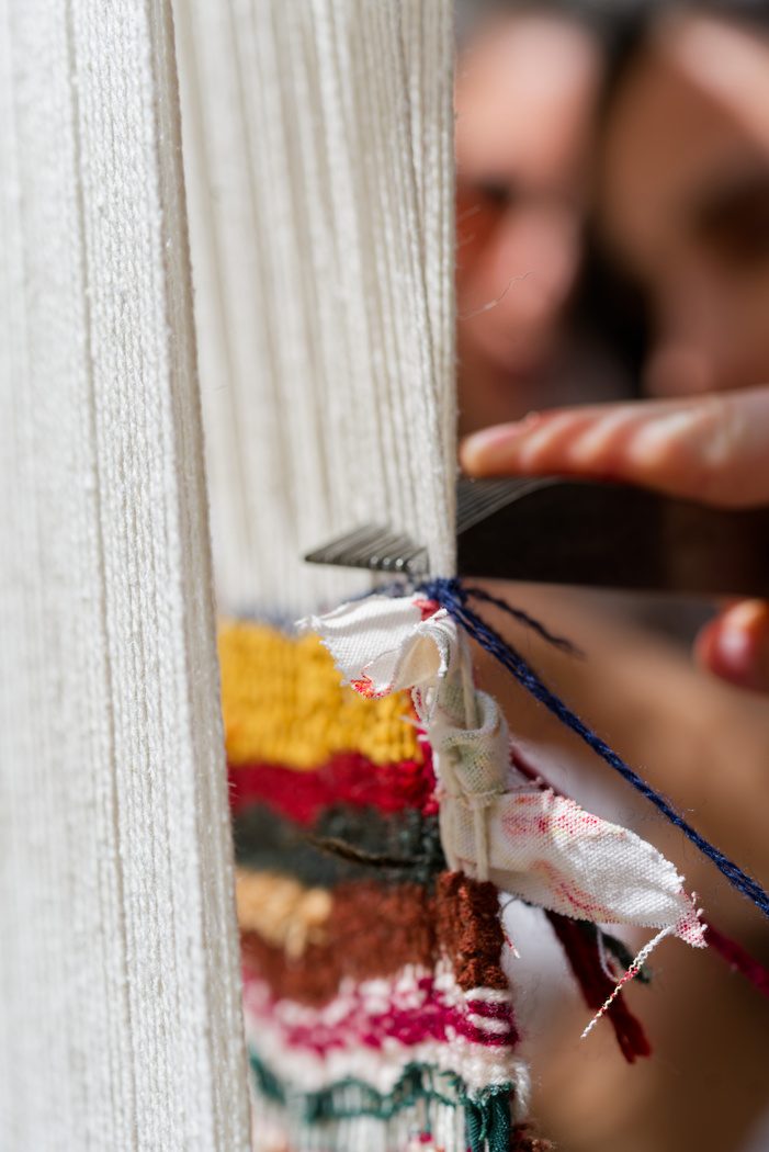 A participant weaving at the loom
