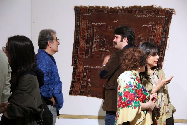 Visitors in conversation in front of the carpet