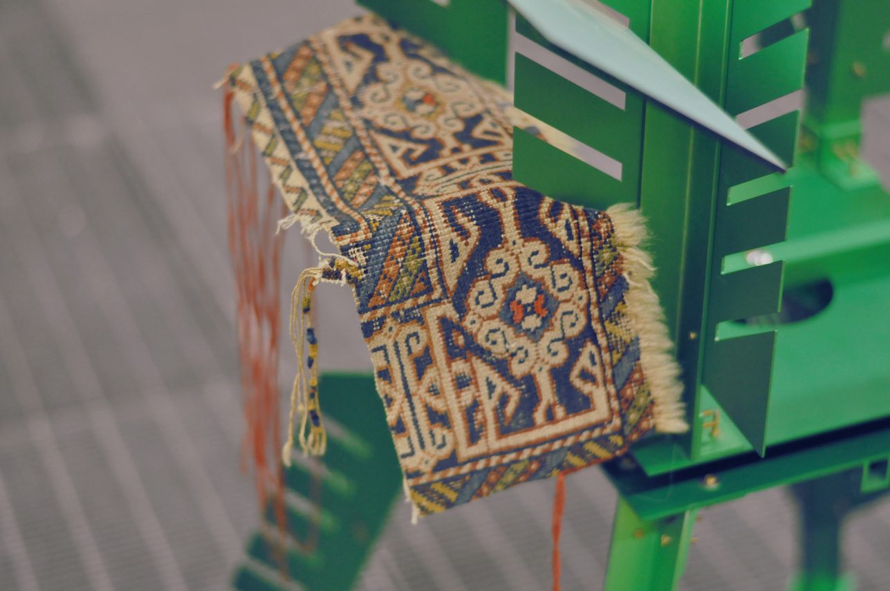 Carpet fragments hung on a green structure