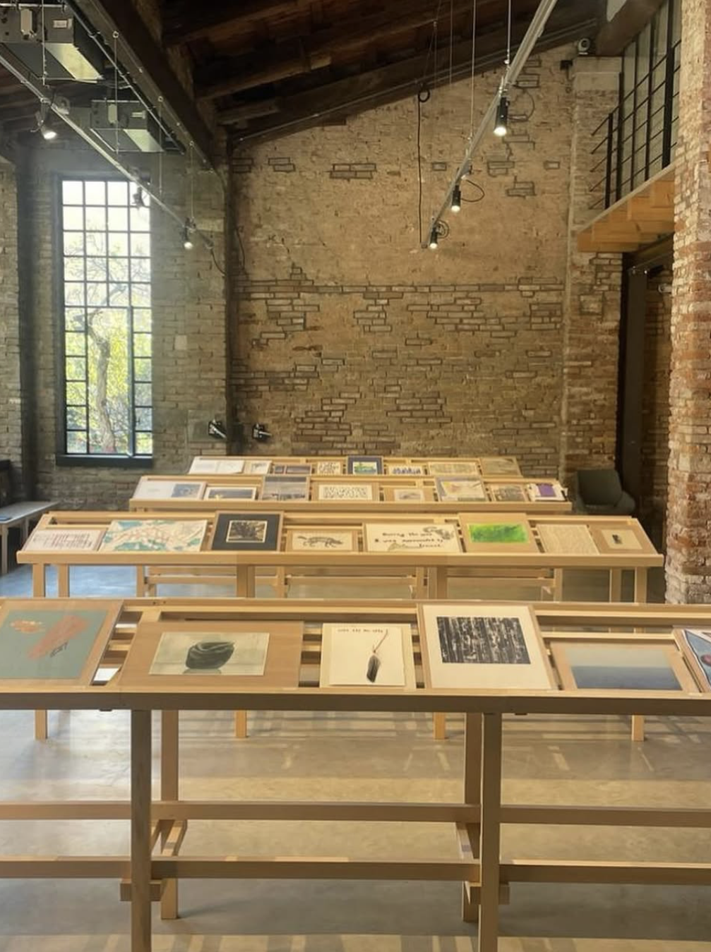 A gallery view of framed artworks arranged on display tables